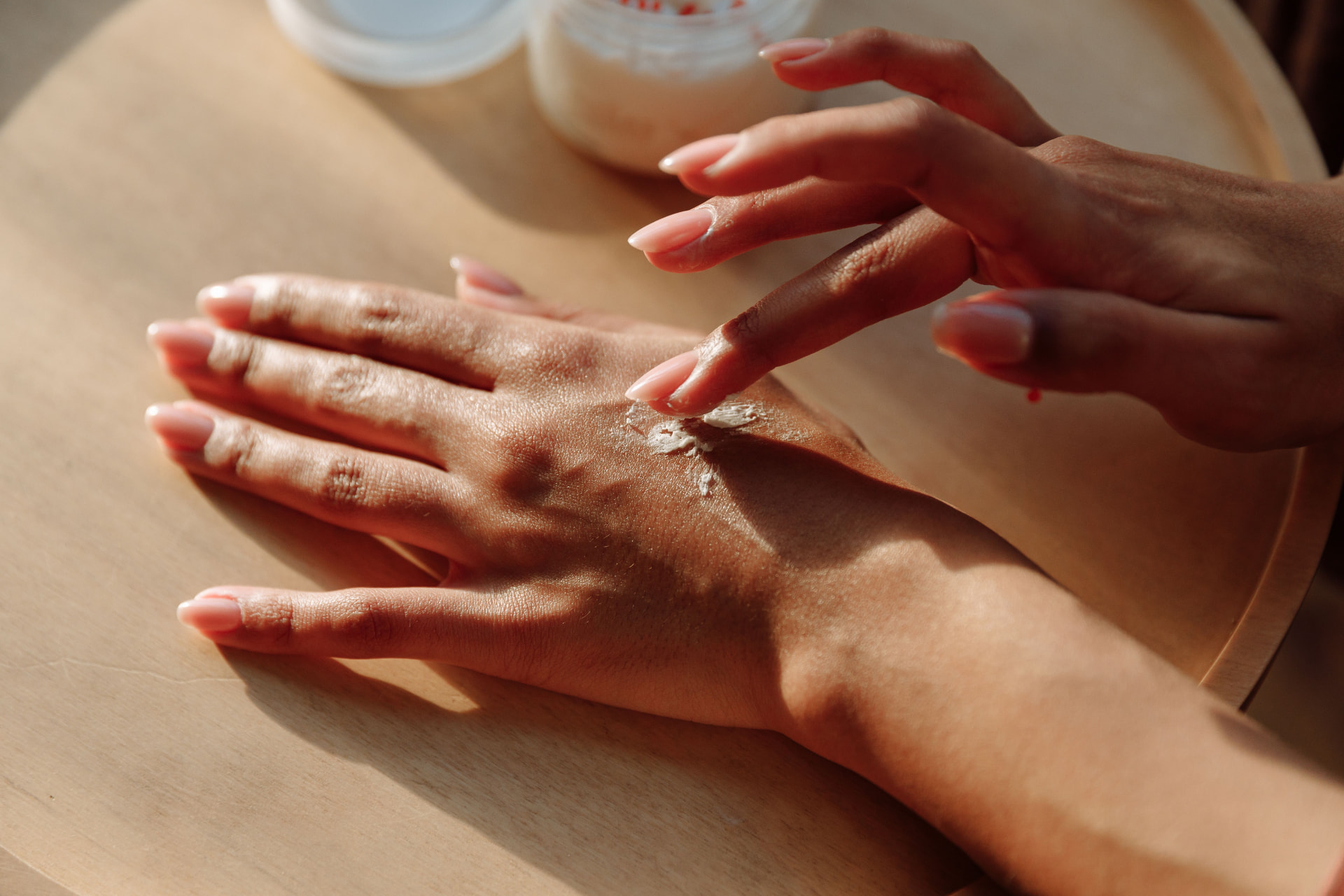Applying cream to the back of a hand